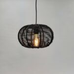 Donkere rieten hanglamp met zichtbaar filament gloeilamp voor sfeervolle interieurverlichting.