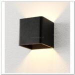 Strakke zwarte wandlamp met inbouwverlichting voor moderne interieurs, creëert sfeervol en gericht licht, ideaal voor woonkamers en hallen.