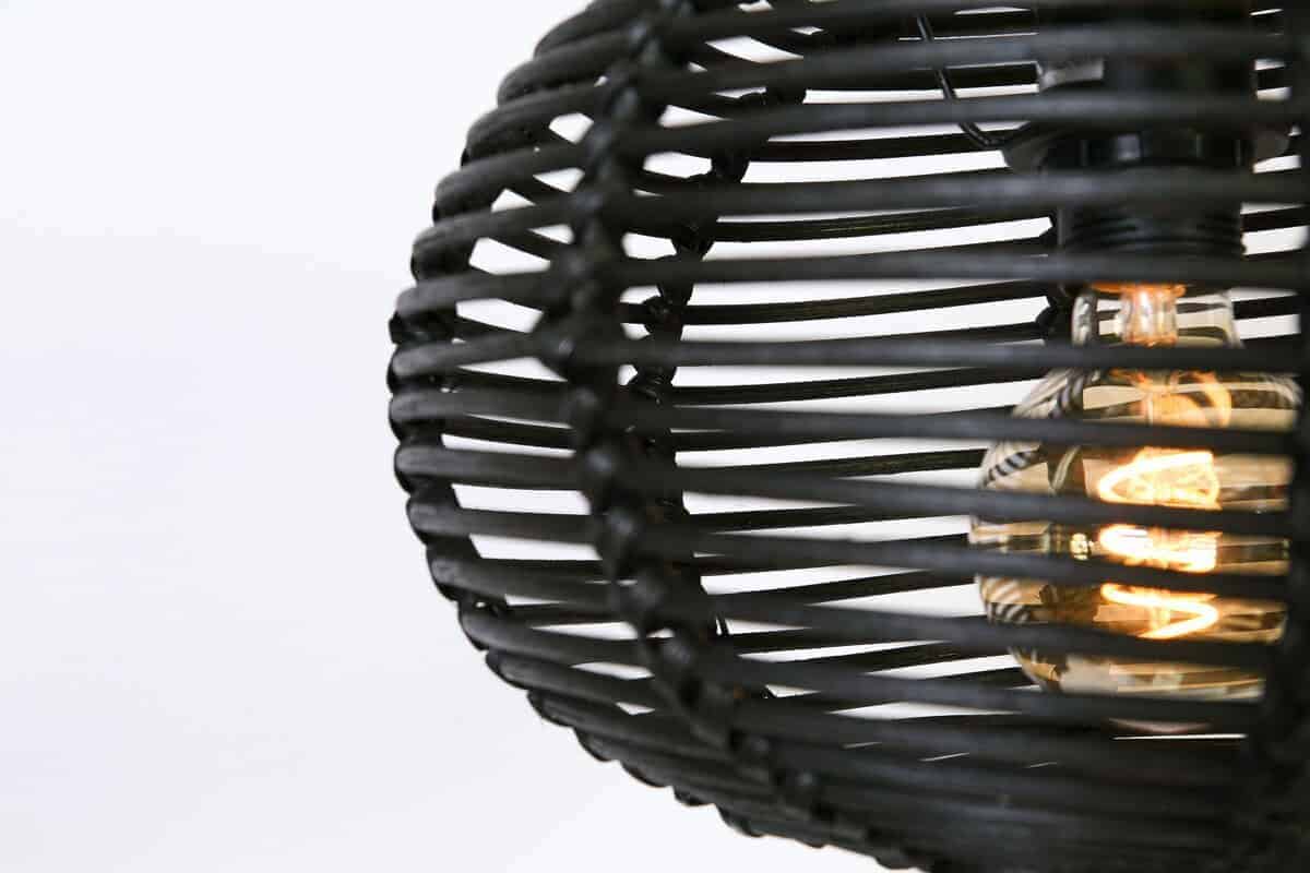 Kleine zwarte rieten hanglamp met een zichtbaar gloeilamp, stijlvolle verlichting voor binnen en buiten.