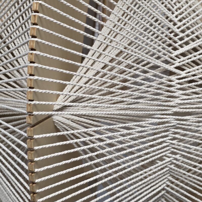 Een close-up van een uniek design houten en touw hanglamp met een moderne uitstraling, perfect voor decoratie en verlichting in huis of kantoor.