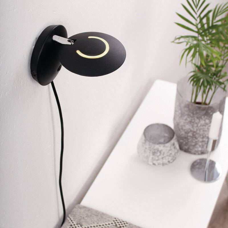 Decoratieve zwarte wandlamp met LED-kring voor sfeerverlichting en modern interieur, ideaal voor woon- of slaapkamer.